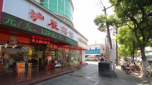 A hotel with a large sign displaying room rates and amenities. - Huchen Fashion Hotel (Shanghai)