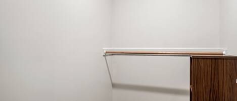 A corner of a room with a wooden cabinet and a white wall.