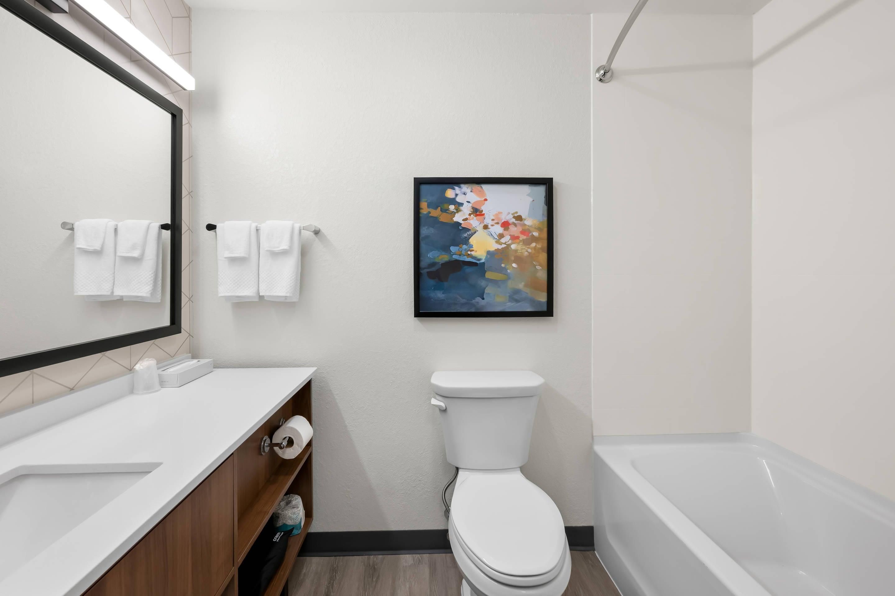 A modern bathroom with a toilet, sink, and bathtub.
