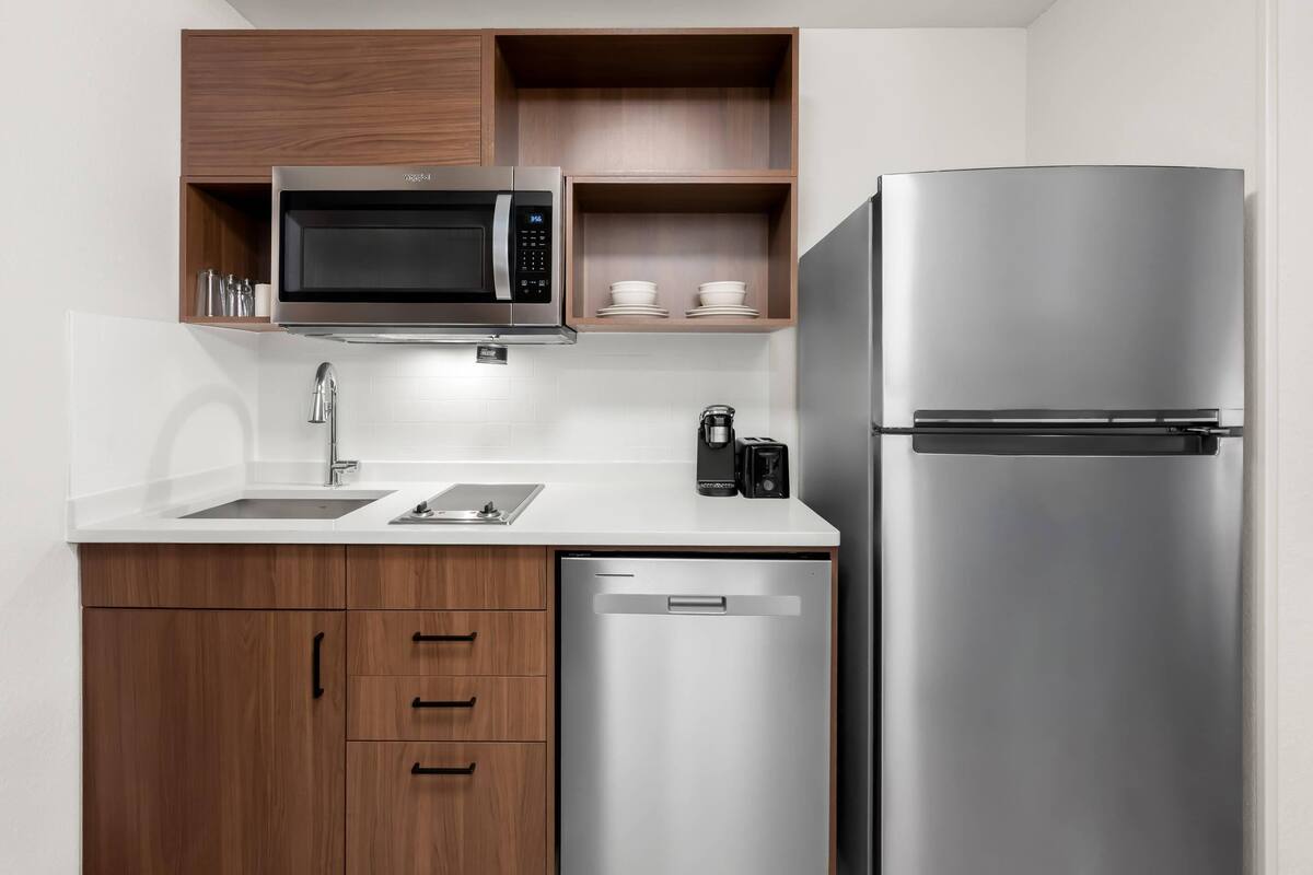 A modern kitchen with a stainless steel refrigerator, a microwave, and a coffee maker.