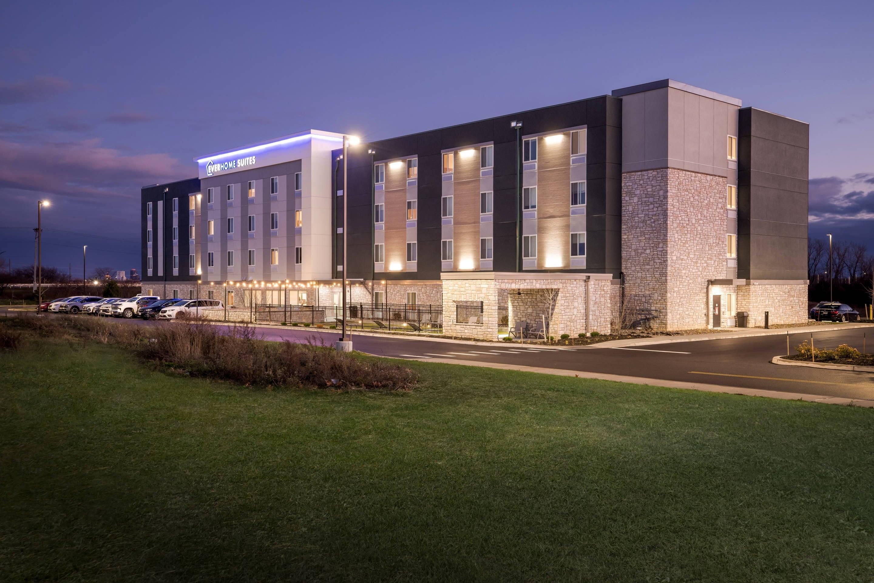 A hotel with a modern design, featuring a stone facade and multiple windows.