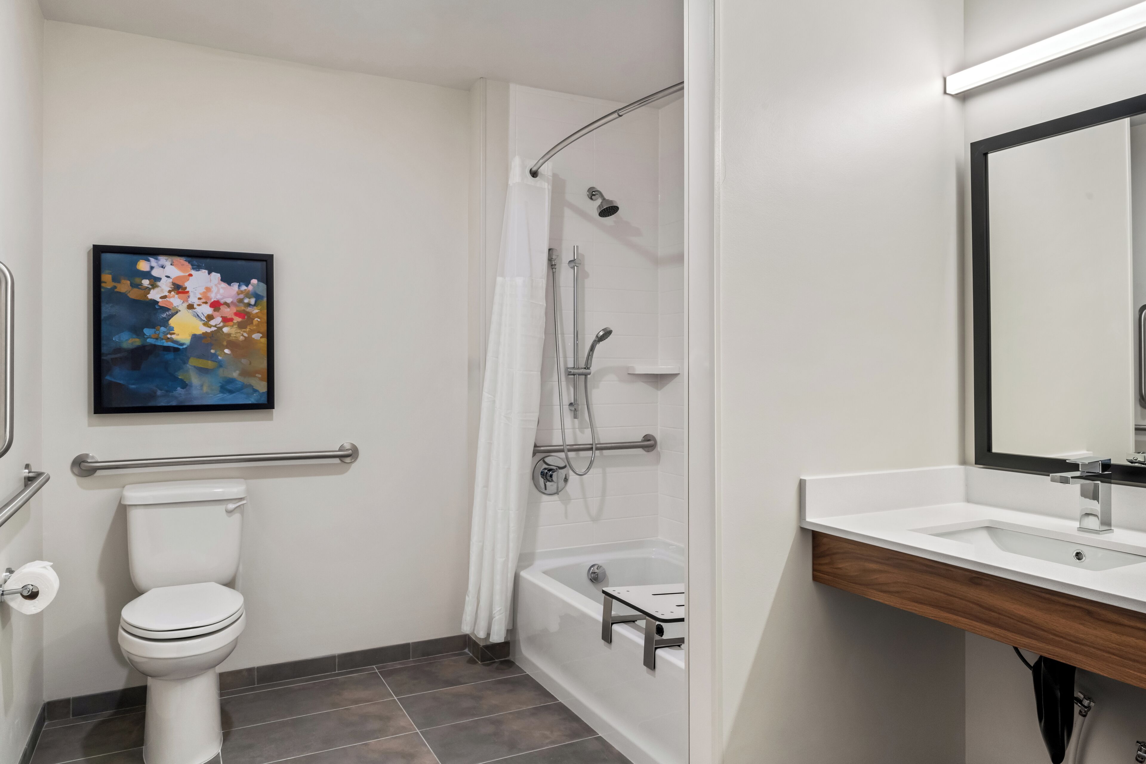 A modern bathroom with a toilet, shower, and sink.