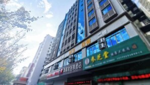 A multi-story building with several visible signs and windows. - Shankee Hotel (Maoming High-Speed Railway Station 1959 Cultural and Creative Pedestrian Street) (Maoming)