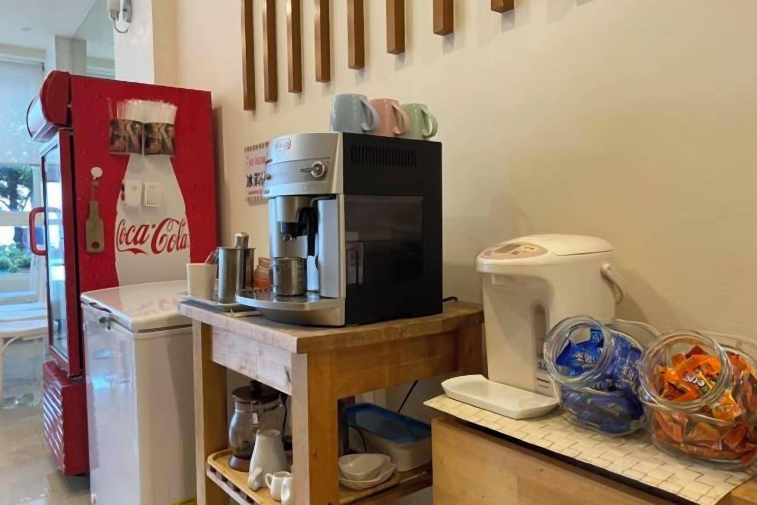 A kitchenette with a coffee machine, a refrigerator, and a microwave.