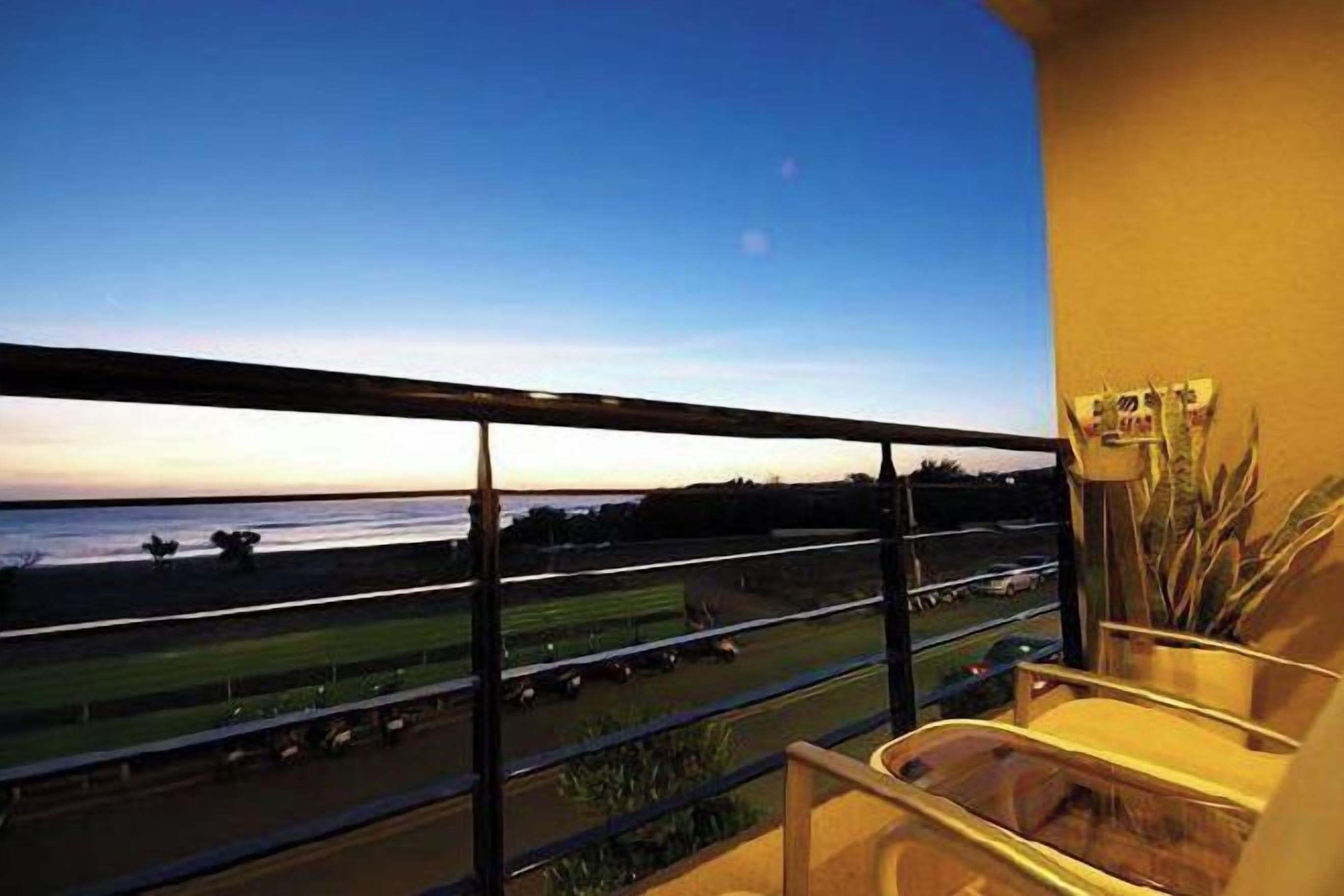 A balcony with a view of a racetrack and a body of water.