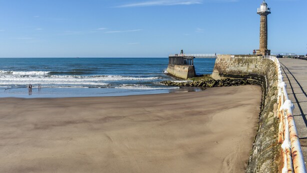 A coastal beach with a lighthouse and a pier. - 2 bedroom accommodation in Whitby (Whitby)