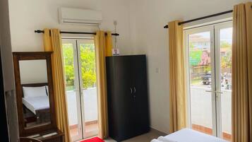 Ein Hotelzimmer mit Bett, einem Kleiderschrank, einem Schreibtisch und einer roten Matte.