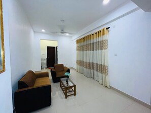 Apartamento Deluxe, balcón, vistas al mar | Zona de estar | Televisión de pantalla plana de 32 pulgadas con canales digitales
