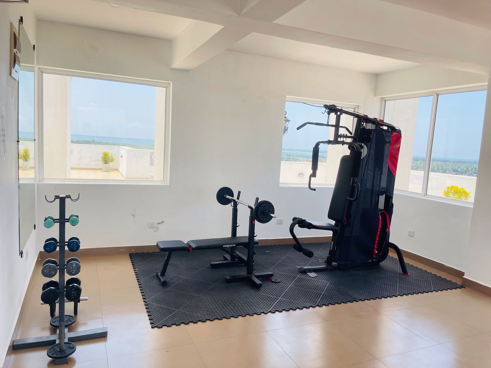 Et fitnessrum med vægte, en bænk og en træningsstang.
