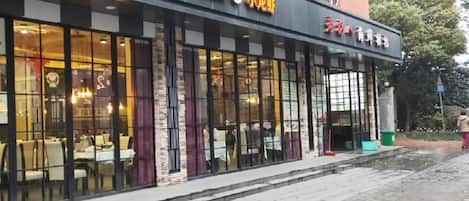 A restaurant with outdoor seating and a clear view of the interior through large windows.
