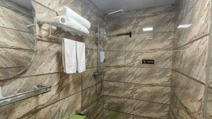 Un baño con ducha, inodoro y lavamanos.