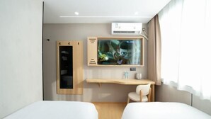 A hotel room with two beds, a desk, a chair, a TV, and an air conditioning unit. - Dongjing Hotel (Shanghai Shanda College Branch) (Shanghai)