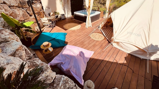 A wooden deck with a hot tub, outdoor furniture, and a tent. - Eco-lodge yurt with luxury Jacuzzi at C&C for ADULTS only (Cantaron)