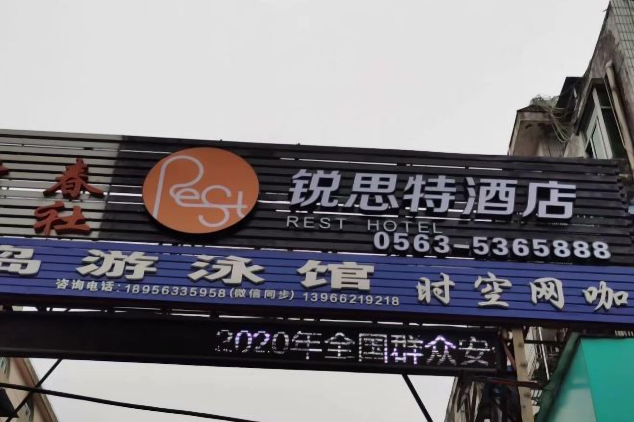 A hotel sign with the name 'Rest Hotel' and contact information.