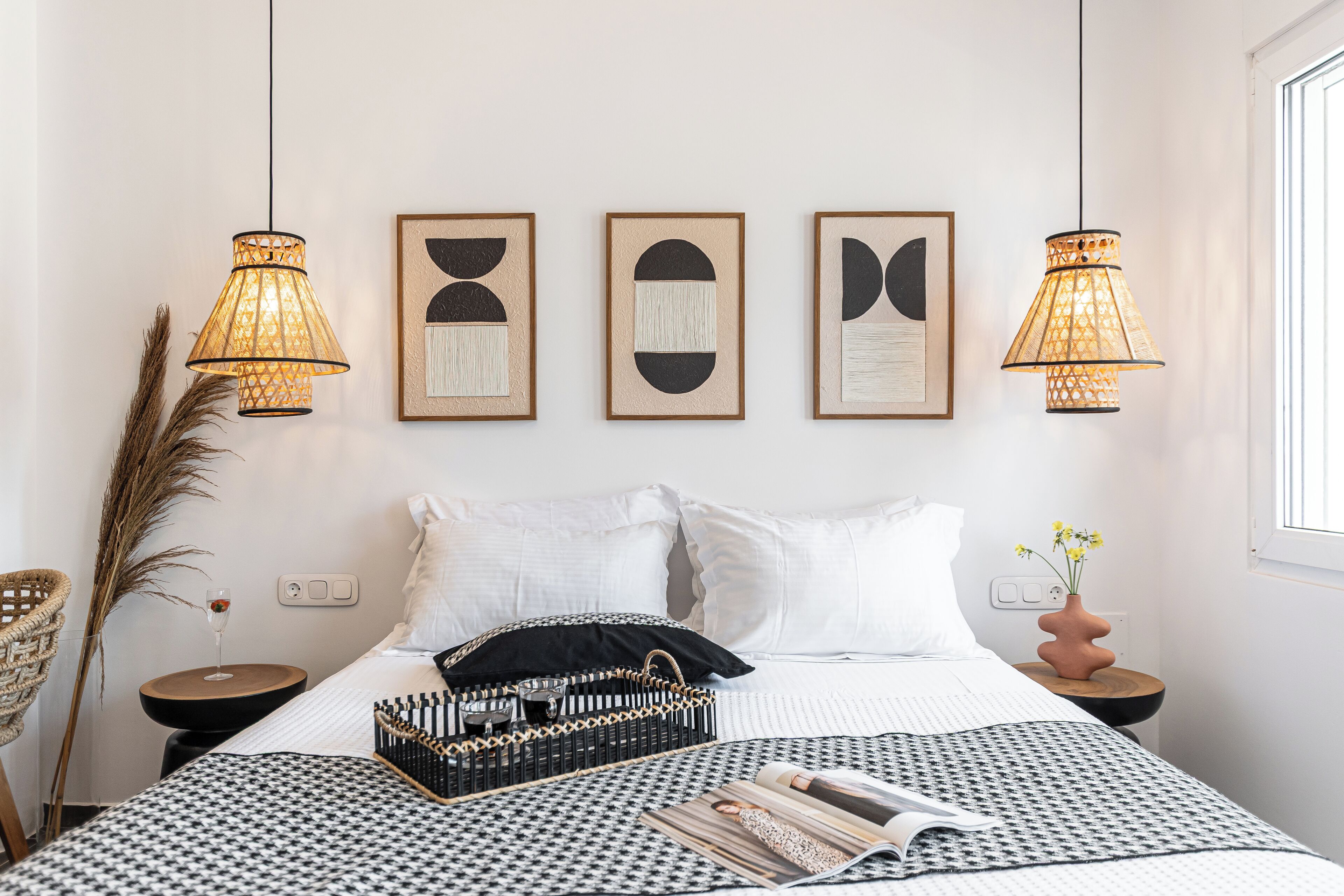 Ein ordentlich eingerichtetes Schlafzimmer mit Bett, Nachttischen und Wandbildern.