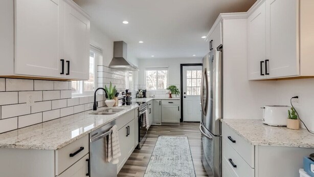 A modern kitchen with white cabinets, a stainless steel refrigerator, and a patterned rug. - The Western Retreat | Hot Tub & Spacious Yard (Westminster)