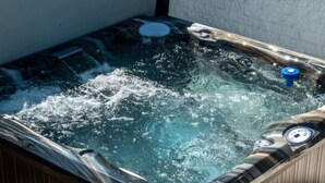A hot tub with water jets, a control panel, and a wooden exterior. - The Western Retreat | Hot Tub & Spacious Yard (Westminster)