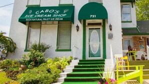 Un edificio blanco con detalles verdes y un letrero que dice "CABO'S ICE CREAM SHOP".