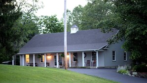 A two-story house with a covered porch, a chimney, and a well-maintained lawn.