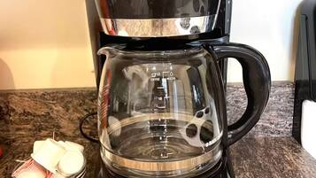 A BLACK+DECKER coffee maker with a digital display, a glass carafe, and a timer.