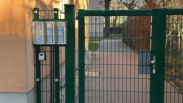 A gated entrance with a green metal gate and a security box attached to the gate. - Apartment Near Schonbrunn Palace Vienna (Vienna)