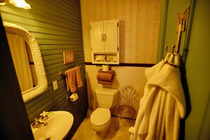 A bathroom with a sink, toilet, and a cabinet above the toilet.