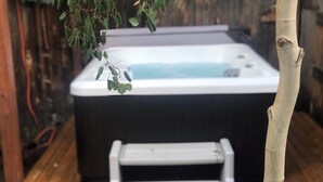 Ein Whirlpool mit einer Leiter in einer Holzterrasse.