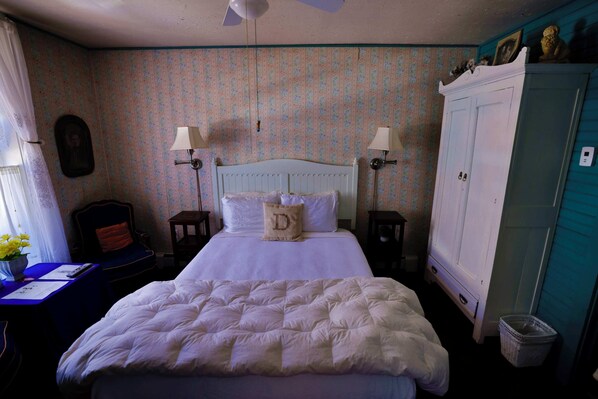 A bedroom with a bed, two bedside tables with lamps, a dresser, and a chair.