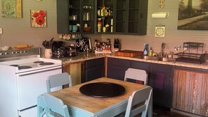 A kitchen with a dining table, chairs, a stove, and cabinets. - #1 Guest House 2Bd 2 Bath Pet Friendly Across from Spa (Silverton)