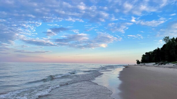 A beach with a clear sky and gentle waves.