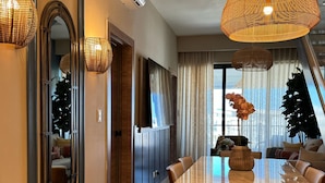 Un comedor moderno con una mesa grande, sillas e dos lámparas colgantes tejidas.