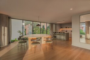 A modern kitchen with a large island, ample natural light, and a view of the city. - Wake BioHotel, a Member of Design Hotels (Medellín)