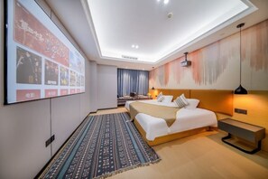 Una habitación de hotel moderna con una cama grande, un escritorio, un televisor montado en la pared y una lámpara de techo.