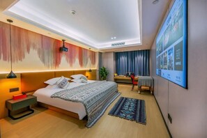 Una habitación de hotel moderna con una cama grande, un escritorio, una silla, un televisor y una lámpara en el techo.