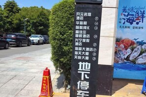Un letrero vertical con nombres de hoteles e íconos que muestran las comodidades.