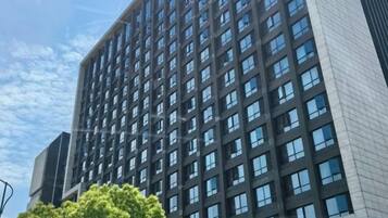 A high-rise building with multiple windows and a clear sky.