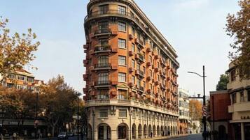 Um hotel de vários andares com fachada curva, diversas varandas e estilo arquitetônico clássico.