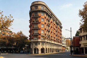 A multi-story hotel with a curved facade, multiple balconies, and a classic architectural style.