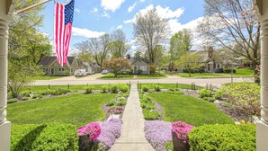 A residential street with houses, a central pathway, and an American flag. - Walk to Main St & Parks: Zionsville Village Home (Zionsville)