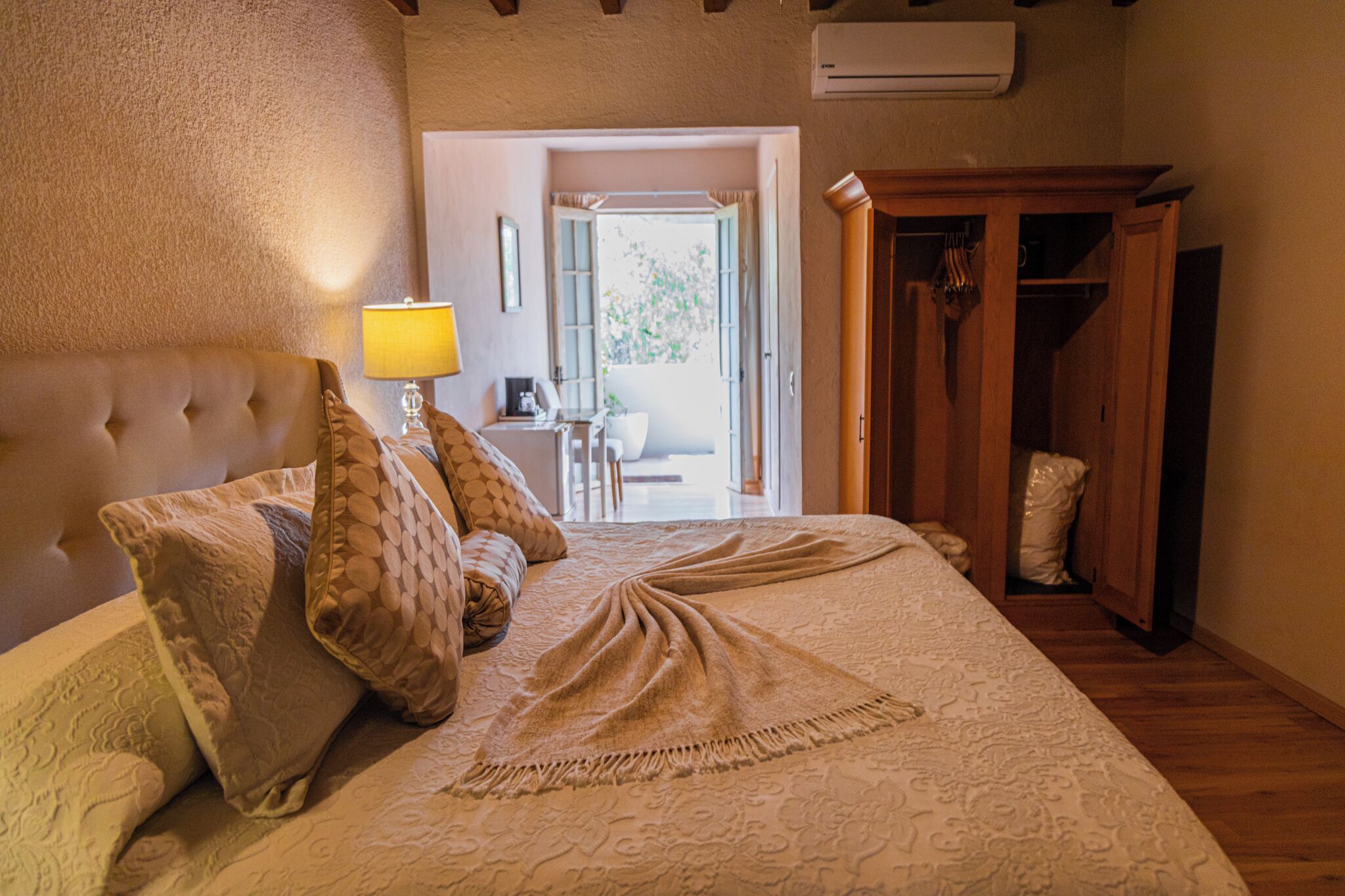 Une chambre à coucher avec un grand lit, une table de chevet avec une lampe et une armoire.