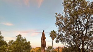 A terrace with a table and chairs, surrounded by a railing and a view of trees and a clear sky. - Hotel Casa Aliz (San Miguel de Allende)