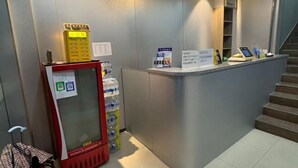 A reception desk with a vending machine, water dispenser, and a staircase. - Shanghai Wuzhou Esports Hotel (Shanghai)