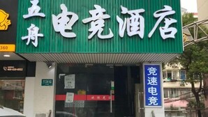 A hotel with a green facade and a sign that reads "土木电亮酒店". - Shanghai Wuzhou Esports Hotel (Shanghai)