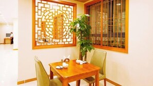 Una habitación tradicional japonesa con suelo de estequilla, una mesa de madera baja con un juego de té y un divisor corredizo shoji.