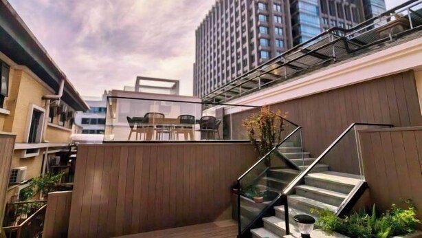 Un edificio moderno con una escalera, asientos al aire libre y vistas a otros edificios.