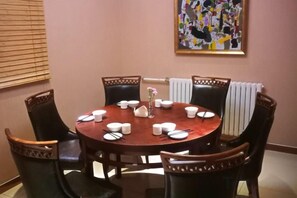A dining area with a round table set for four, surrounded by six chairs. - Beijing Dongdan Hotel (Beijing)