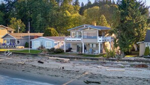Une zone résidentielle côtière comprenant des maisons, une plage et une étendue d’eau.
