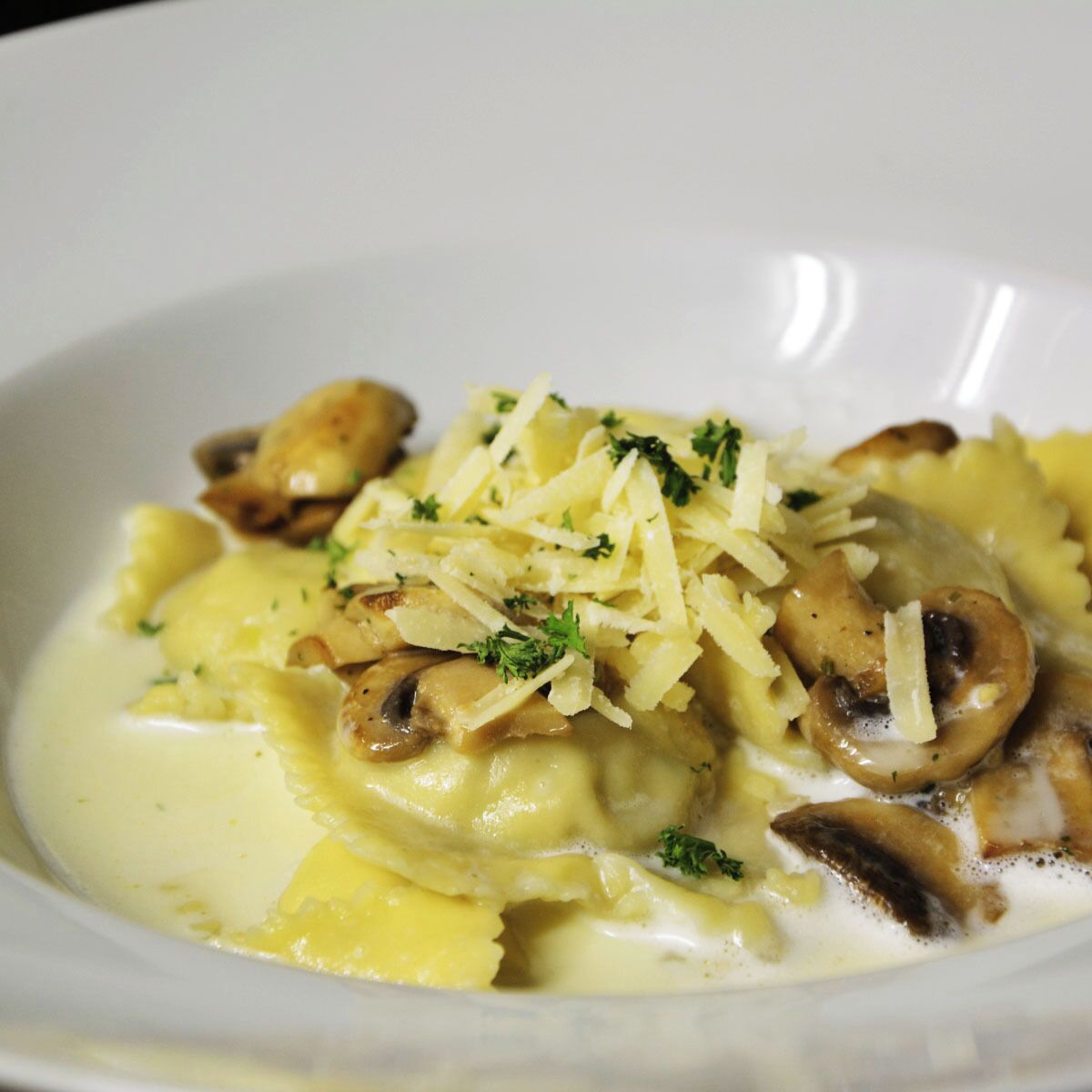 A bowl of pasta with mushrooms and cheese.