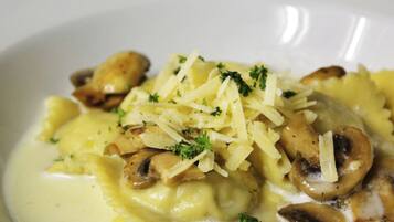 A bowl of pasta with mushrooms and cheese.