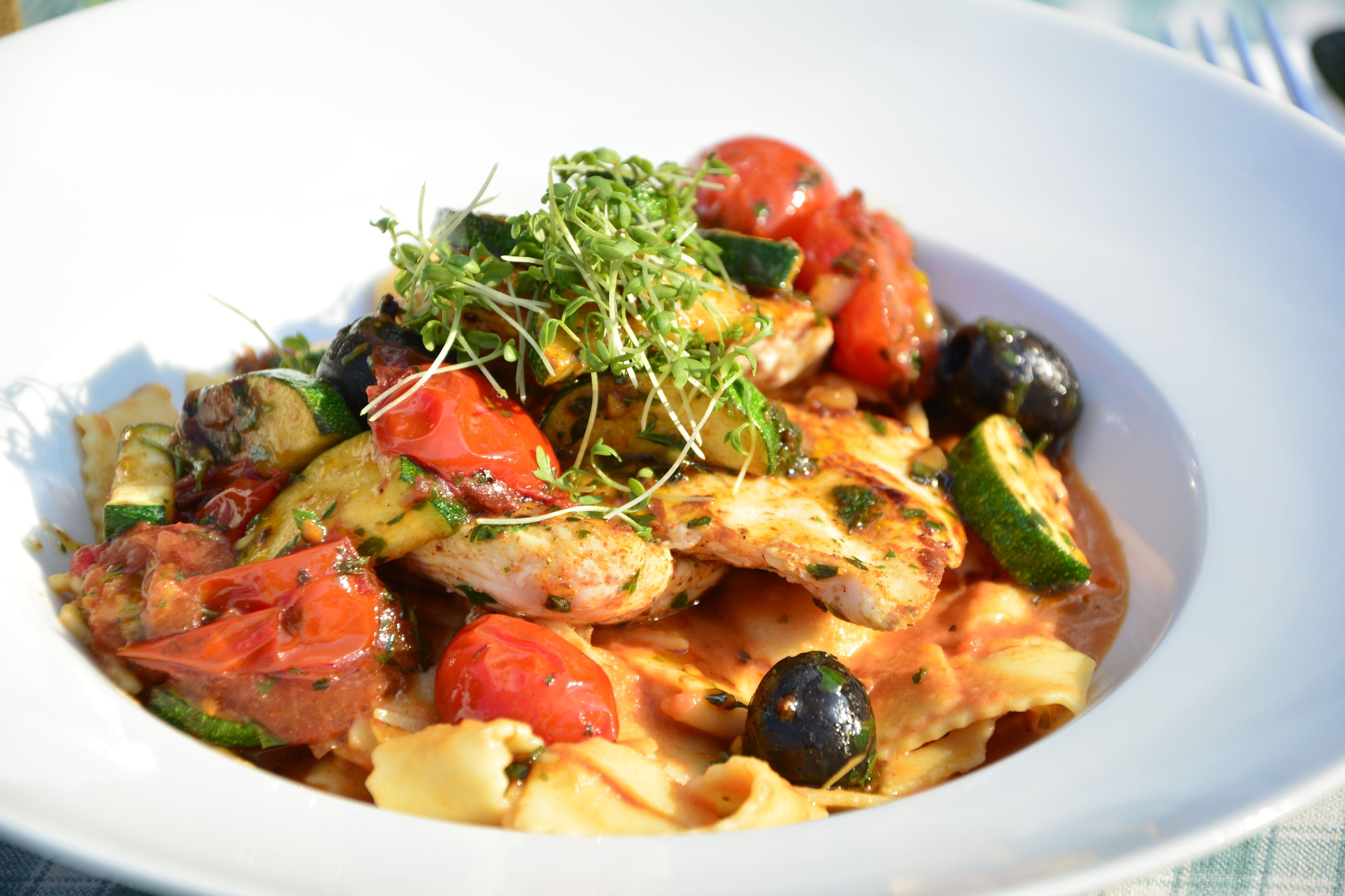 A plate of pasta with vegetables and chicken.